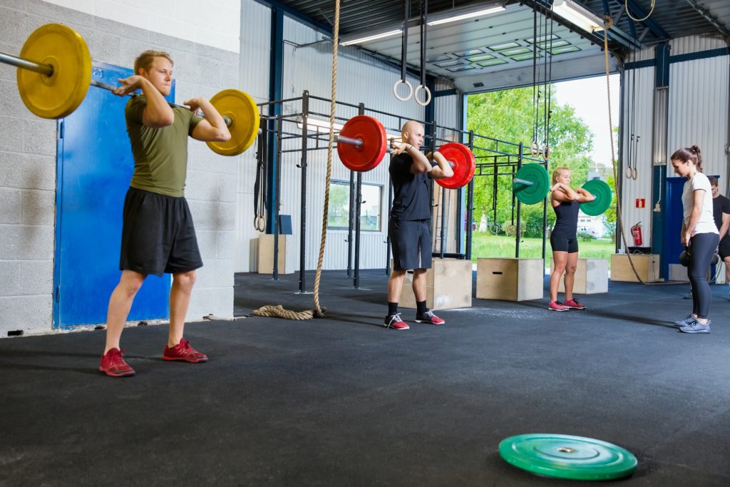 Team training with weights and kettlebells at fitness gym